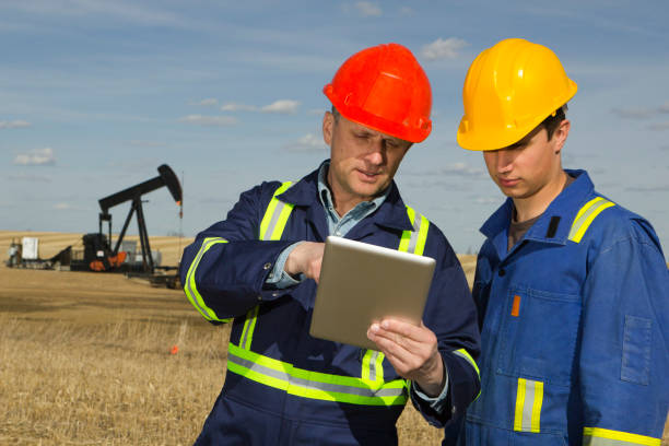 масло работников и планшетный пк - oil industry digital tablet manual worker mining стоковые фото и изображения