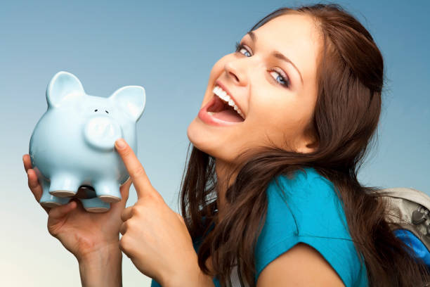 istock Smiling college student with blue piggy bank 155417594