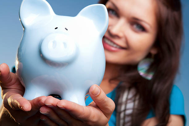 istock Smiling college student with blue piggy bank 155417610