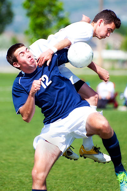 Two Male Soccer Players Collide Creating Mid-air Chaos stock photo