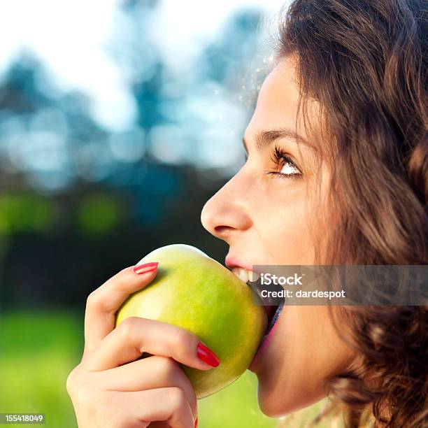 Joven Mujer Comer Manzana Verde Foto de stock y más banco de imágenes de Manzana - Manzana, Mujeres, Comer