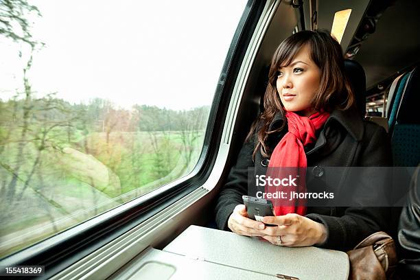 Junge Asiatische Frau Die Mit Dem Zug Stockfoto und mehr Bilder von Eisenbahn - Eisenbahn, Handy, Schweiz