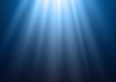 Bright rays of shining blue light on blue water background. Abstract religious or heaven background.