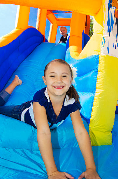 crianças brincando em um toboágua inflável de rebatimento house - inflatable slide sliding child - fotografias e filmes do acervo