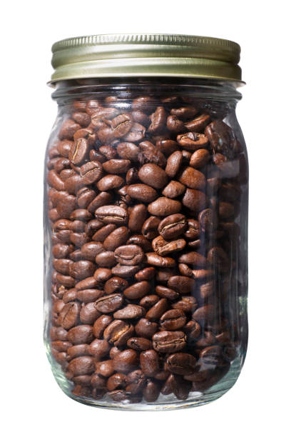 Lot of roasted coffee beans in glass jar, close up