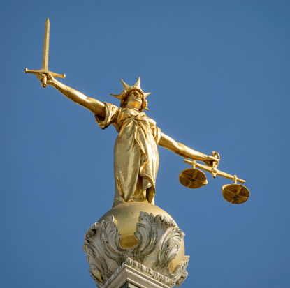 Close-up of the statue of Lady Justice, holding a sword and the scales of justice, located on top of the dome above the Old Bailey (Central Criminal Court) in London.  Lady Justice is based on Justitia, the Roman goddess of justice.