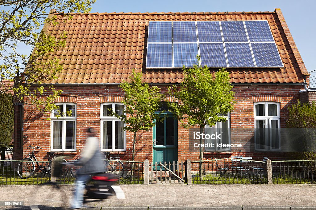 Cute house Little Traditional northern Brick house with photovoltaic technology on the roof Solar Panel Stock Photo