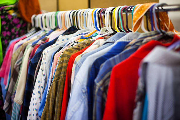 abbigliamento rack in un negozio di articoli di seconda mano - vestiti usati foto e immagini stock