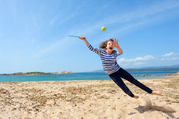 mädchen spielen beach-ball - arms outstretched teenage girls jumping flying stock-fotos und bilder