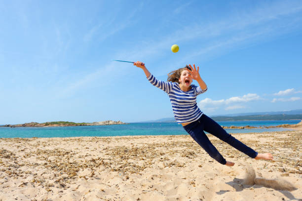 девочка, играя с пляжный мяч - arms outstretched teenage girls jumping flying стоковые фото и изображения