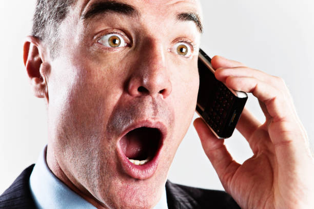 istock Open-mouthed businessman using cell phone is surprised and shocked 155419917