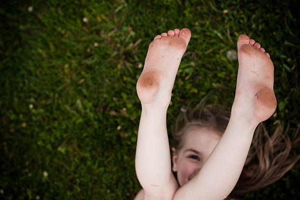 Running children's legs. Children's legs running along the path close-up. Red garden path. The concept of childhood. Barefoot childhood. Garden path after the rain.
