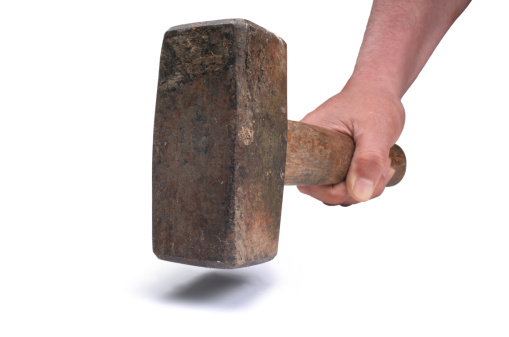 Male hand holding an old rusty heavy lump hammer.