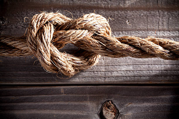 Knot. Love. Tension. Rope tied in knot on wood. knotted wood stock pictures, royalty-free photos & images