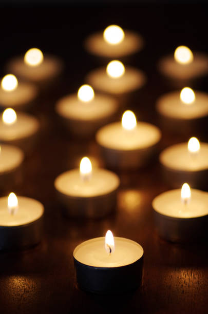 Candles alight On Polished wood surface.