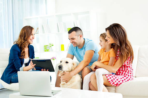 Family Meeting With Financial Advisor Family with two children Meeting With Financial Advisor presenting new bank offers and investments on paper. Financial Advisor pointing with pen to some new offers. animal related occupation photos stock pictures, royalty-free photos & images