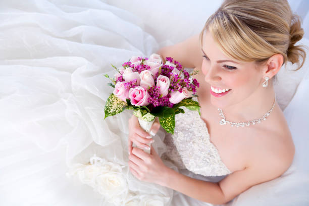istock Smiling bride holding pink bouquet 155421061