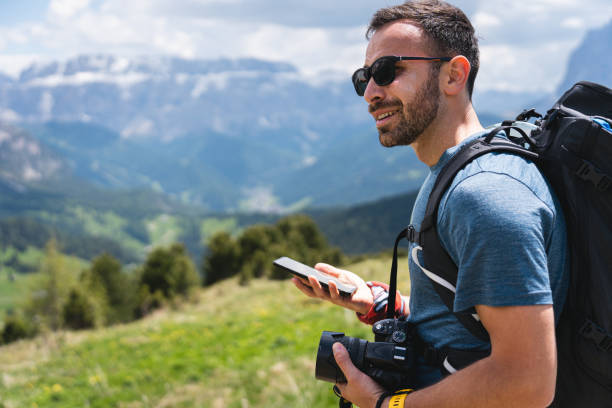 istock Male hiker using mobile phone, while admiring the view of Dolomites 1554211780