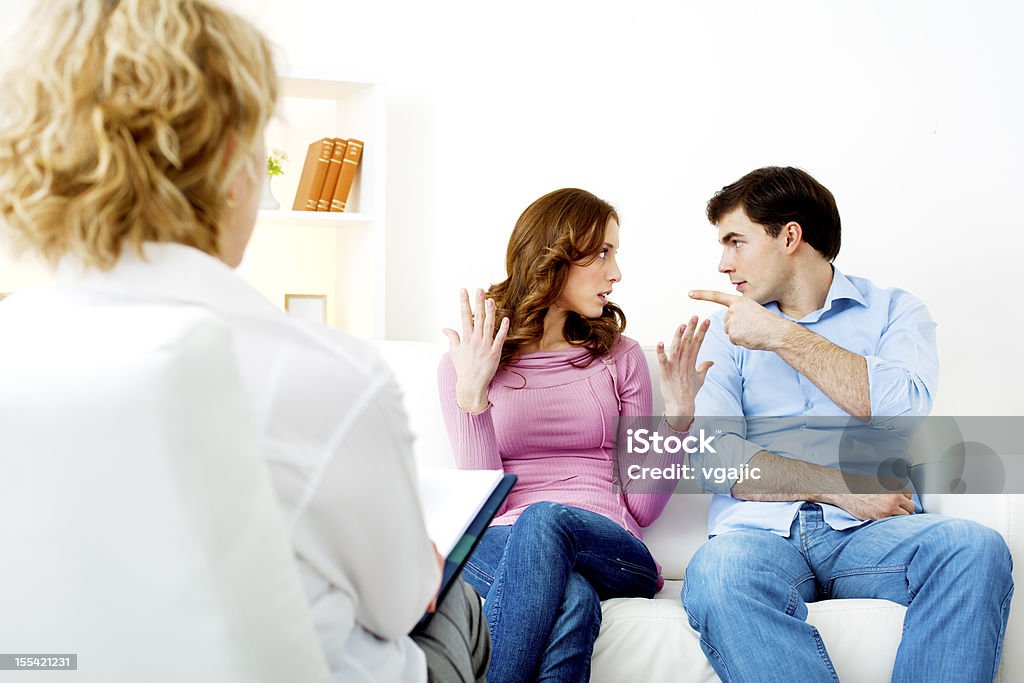 Couple Arguing at Counselor. Couple having counsel session with marriage counselor, arguing and man behaving badly. Arguing Stock Photo