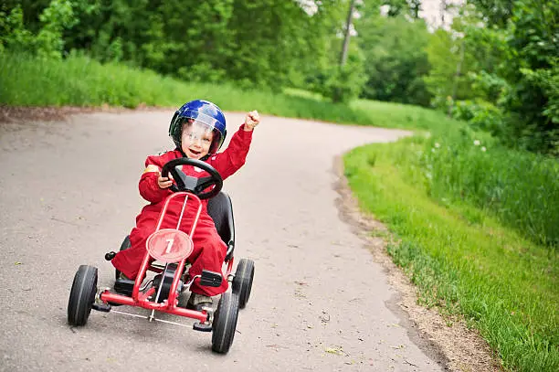 Little boy winning a go-kart race. 