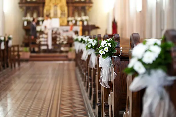 Church decorated with flower bouquets during the Wedding ceremony, selective focus.