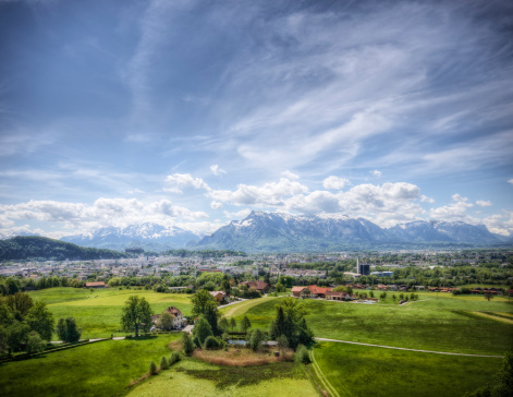 Wide-angle landscape of the plains before the city of Salzburg and the Alps rising in the distance. High dynamic range photo.  