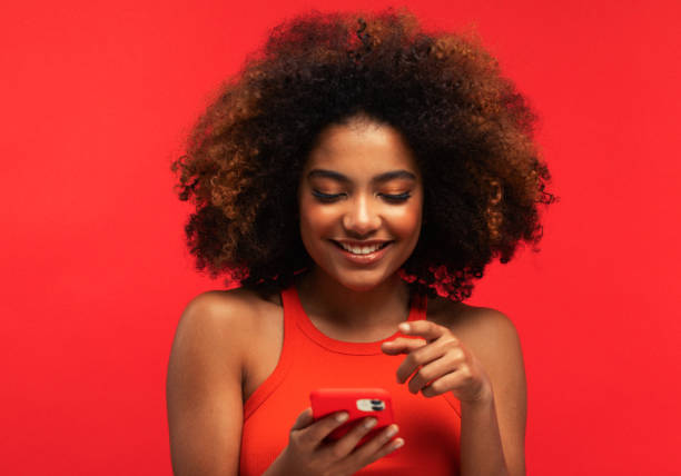 Portrait of ethnic woman holds modern mobile phone, uses electronic device on surfing web Portrait of lovely ethnic woman holds modern mobile phone, uses electronic device on surfing web, connected to wireless internet teenage girl before and after make up stock pictures, royalty-free photos & images