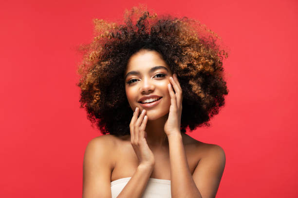 Portrait of Young African model with a beautiful makeup Portrait of Young African model with a beautiful makeup over red color background teenage girl before and after make up stock pictures, royalty-free photos & images