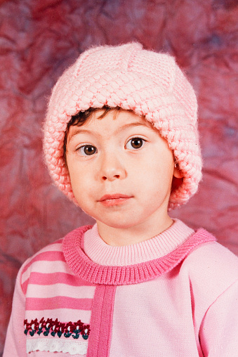Portrait of a girl with a crocheted cap looking at the camera in the 90s in Brazil.