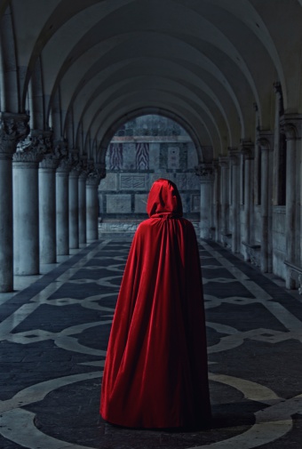 Woman in red cloak walking away