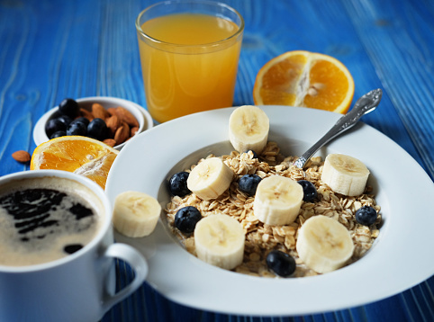 Healthy breakfast served with scrambled eggs, cereals with fruits, bread and honey.