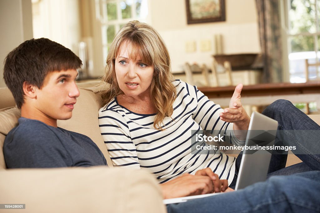 Madre e hijo de adolescente defendiendo en SOFÁ - Foto de stock de Adolescente libre de derechos