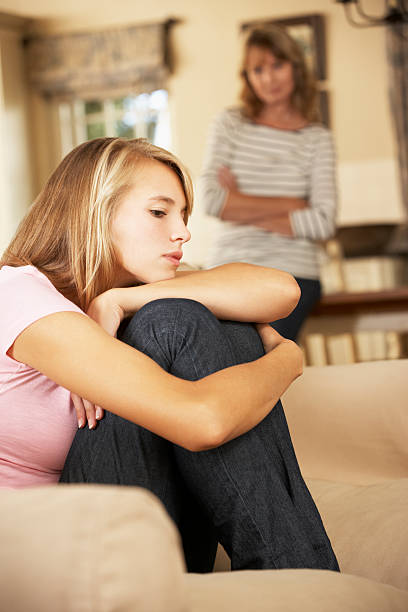 istock Grumpy Teenage Daughter Sitting On Sofa 155428025