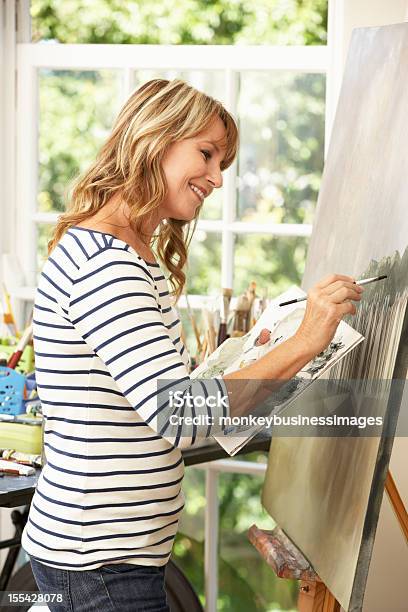 Mujer Trabajando En Pintura De Artista En El Estudio Foto de stock y más banco de imágenes de Ilustración