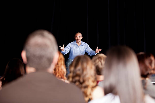 Young man performing on stage for an audience  comedian stock pictures, royalty-free photos & images