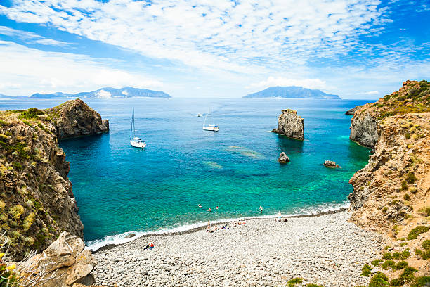Bay of Panarea Cala Junco - small bay of Panarea - one of Aeolian Islands near Sicily (Italy). Lipari and Salina islands visible on the horizon. sicily stock pictures, royalty-free photos & images