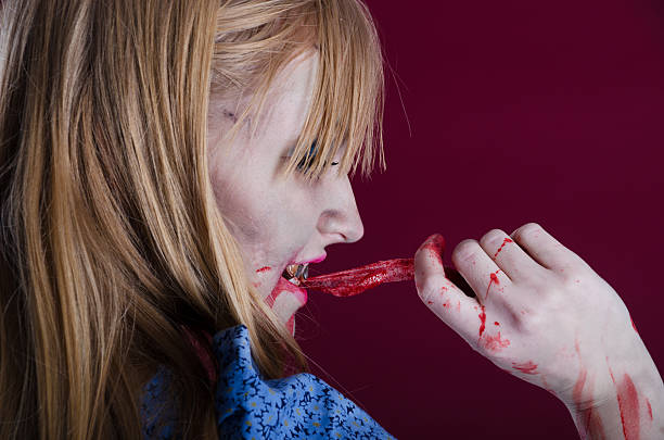 istock Zombie Alice biting strip of flesh, side view. 155428400