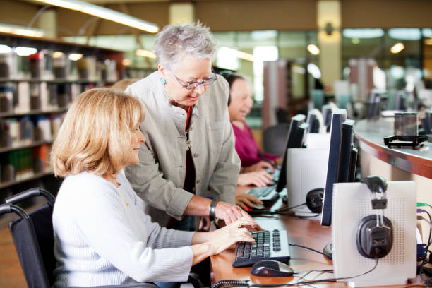 istock Librarian helping a group of seniors working on computers 155428485