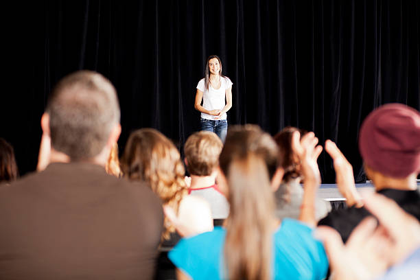 adudience taper dans les mains d'une jeune fille sur la scène - speech talking teenager student photos et images de collection