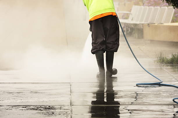 Worker Steam Cleans Sidewalk stock photo