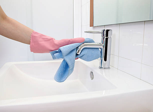 Cleaning Faucet The woman, who is cleaning the faucet with microfiber cloth and gloves microfiber stock pictures, royalty-free photos & images