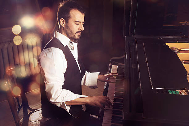handsome piano player stock photo