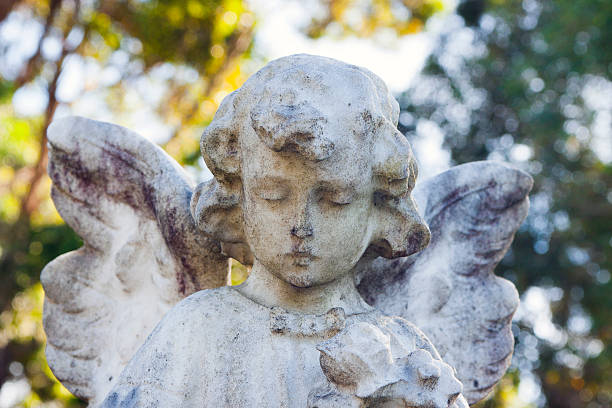 Weathered marble statue of little angel Closeup weathered marble statue of little angel from cemetery, full frame horizontal composition winged cherub stock pictures, royalty-free photos & images