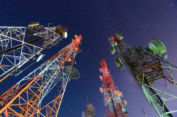 Five telecommunication towers under a night sky 