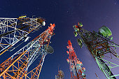 Five telecommunication towers under a night sky 
