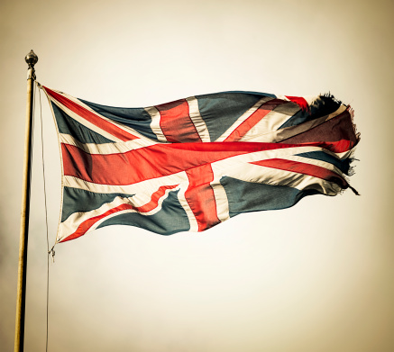 China and Britain flags against blue sky background