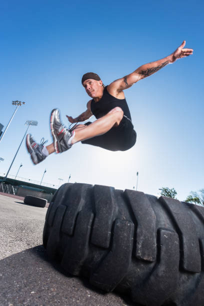istock Man Jumping Truck Tire 155429411