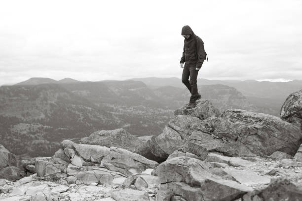 istock Lone Man Standing On Top of Rocks and Cliff 155429785