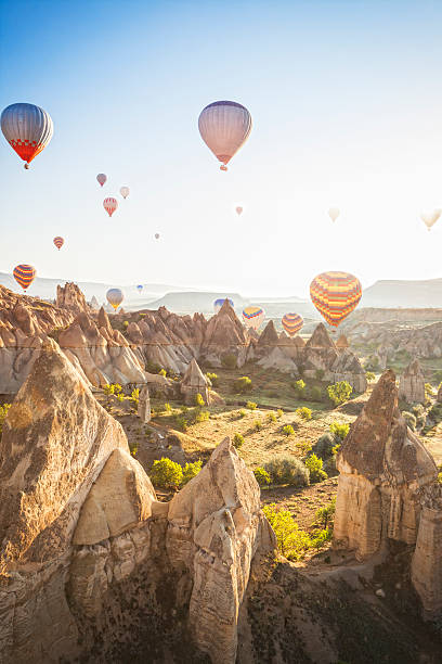 Hot air balloons over Love Valley, Cappadocia, Turkeys Hot air ballons over Love Valley near Goreme and Nevsehir in the center of Cappadocia, Turkey (region of Anatolia). This shot taken shortly after sunrise shooting into the sun. Sun flares visible. tufa photos stock pictures, royalty-free photos & images