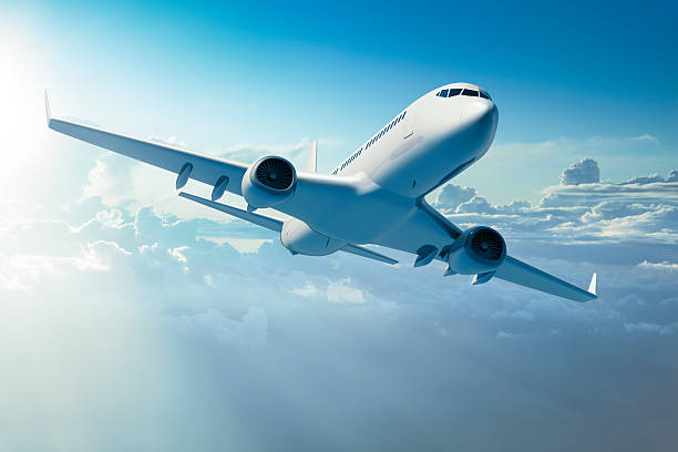 Passenger jet airplane over clouds stock photo